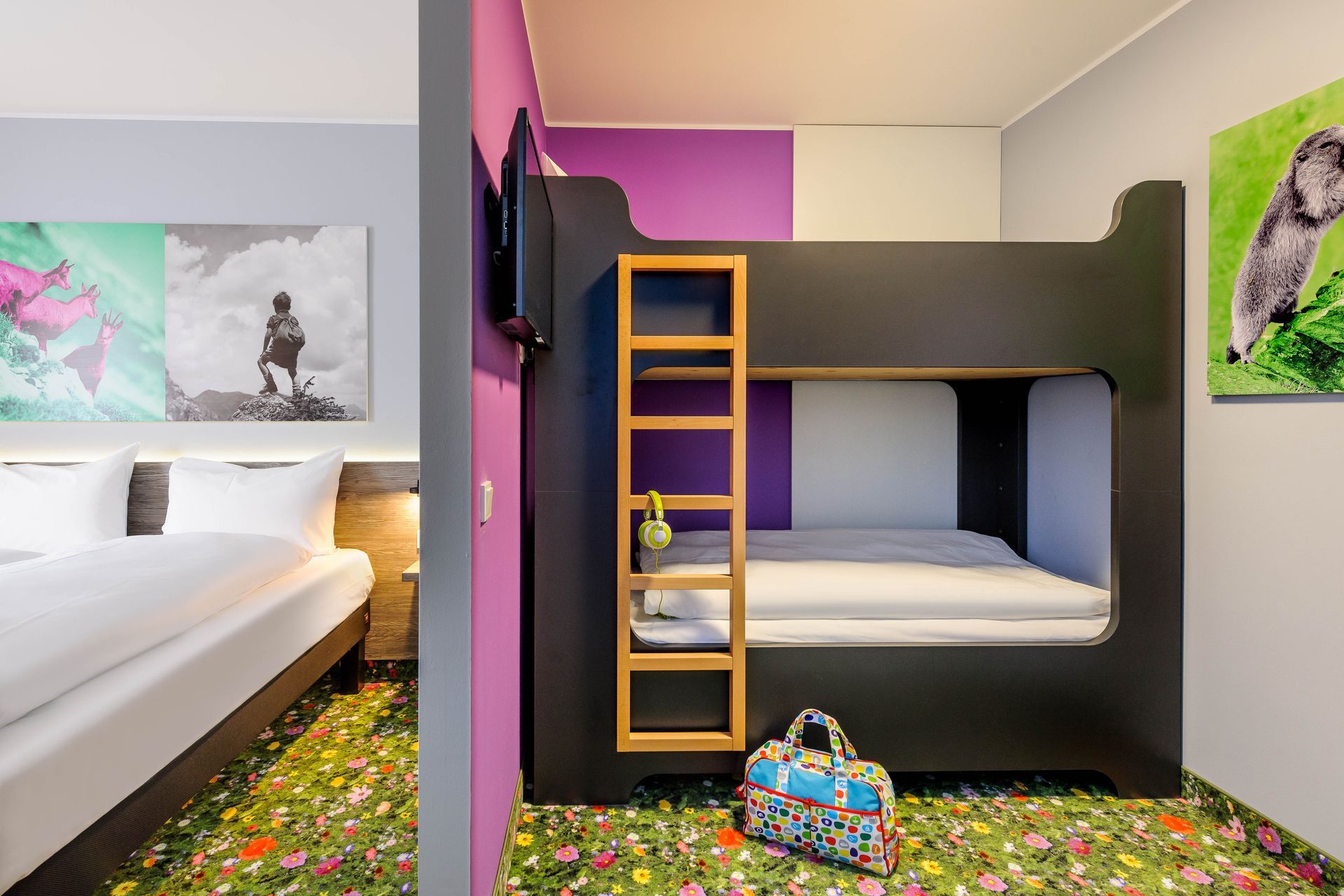 Kinderzimmer mit Etagenbett, Leiter, geblümtem Teppich und einem Bett daneben