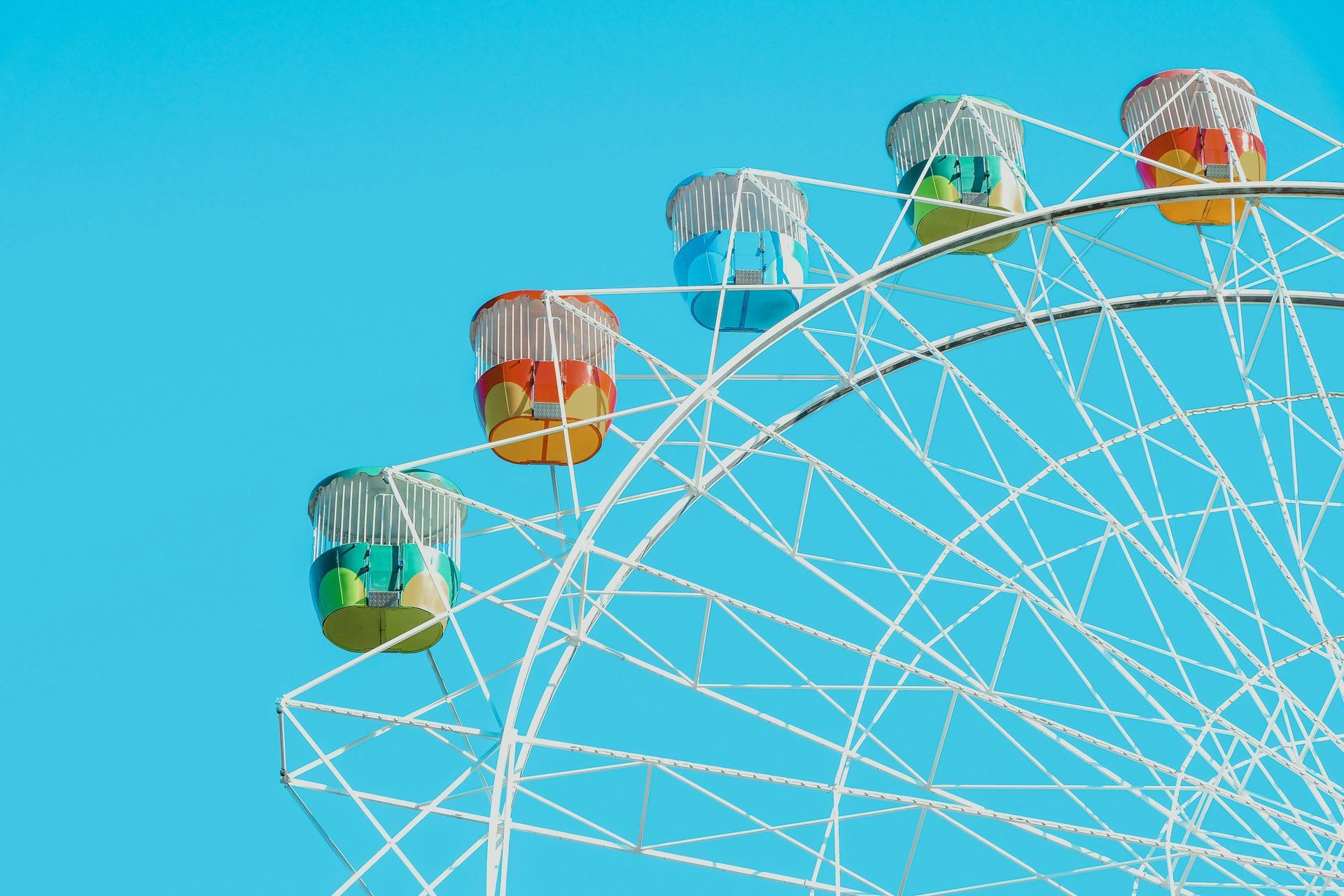 Bunte Gondeln des Riesenrads vor strahlend blauem Himmel