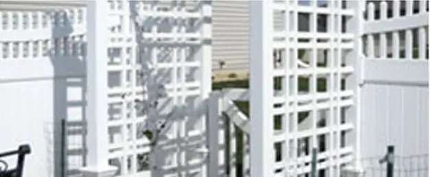 A group of white buildings with a fence in front of them. A group of white buildings with a fence in front of them.