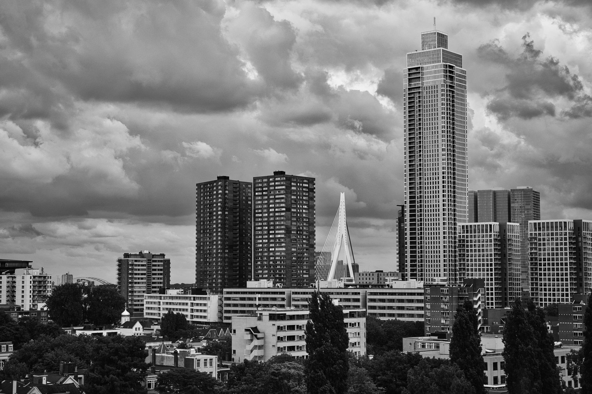 Black-and-white city skyline with tall modern buildings under cloudy skies