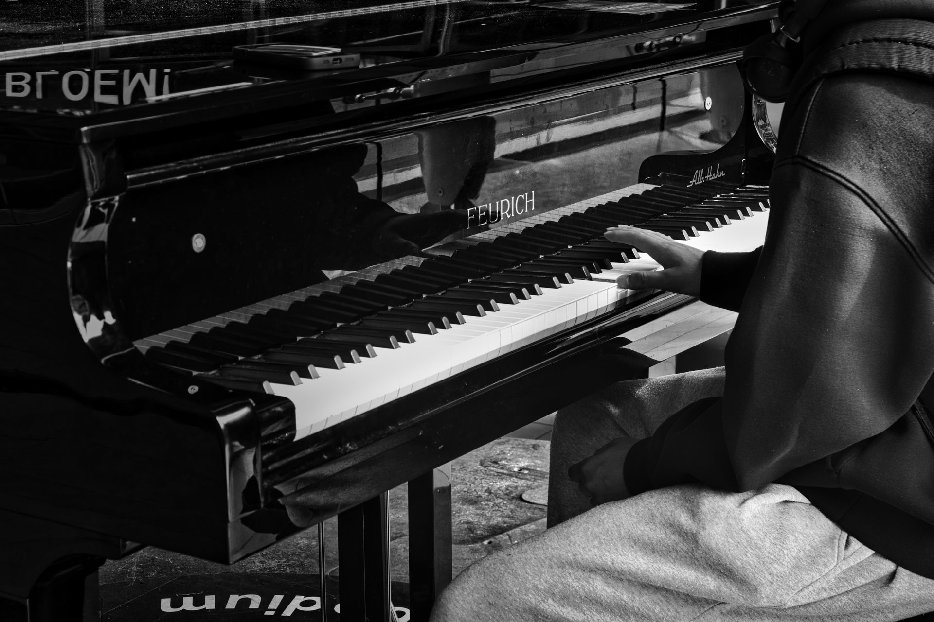 Person playing a piano in a black-and-white photo