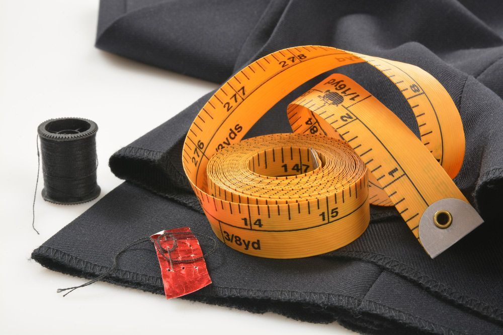 A Yellow Measuring Tape Is Laying On A Piece Of Black Fabric — The Sewing Machine Doctor In Forest Glen, QLD