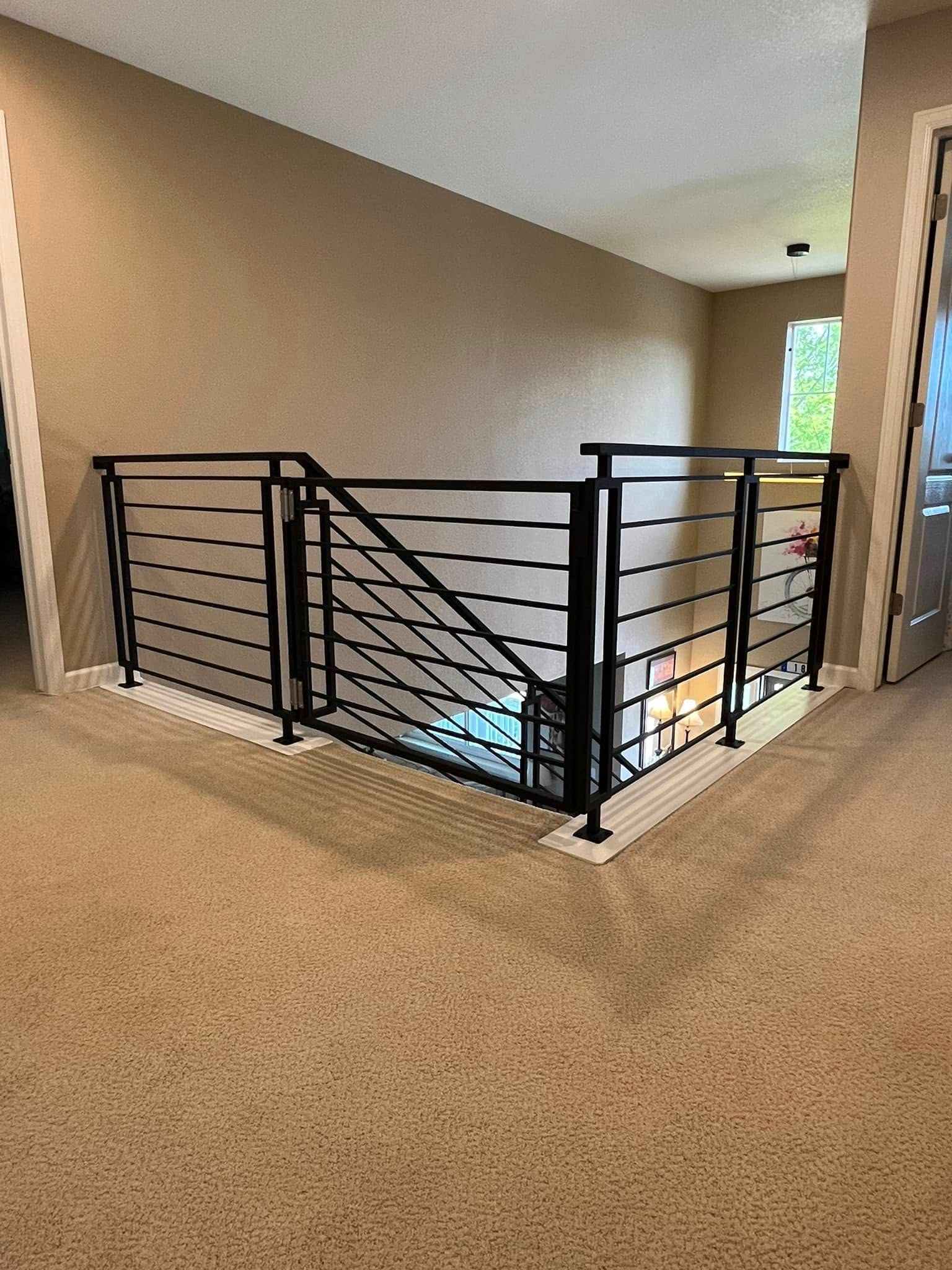 Black metal railing around a hallway opening, beige walls, and light brown carpet.