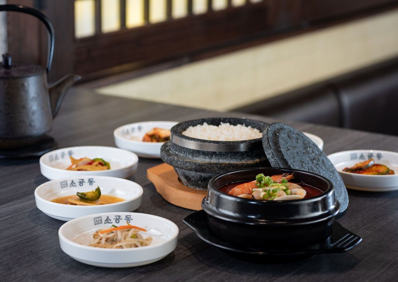 Korean meal with rice, soup, side dishes, and grilled dish on a table
