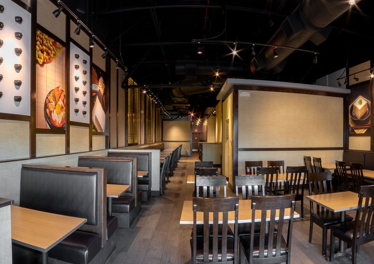 Empty restaurant interior with booths, wooden tables, and warm lighting