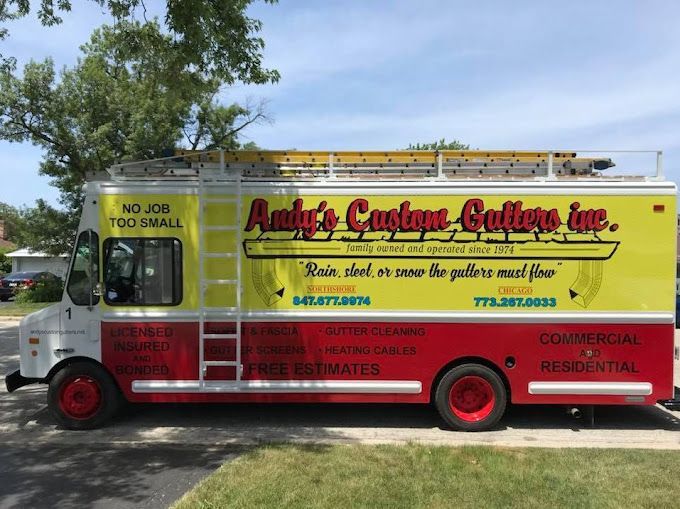 Yellow, red, and white Andy's Custom Gutters truck with ladder on top, parked on a street.