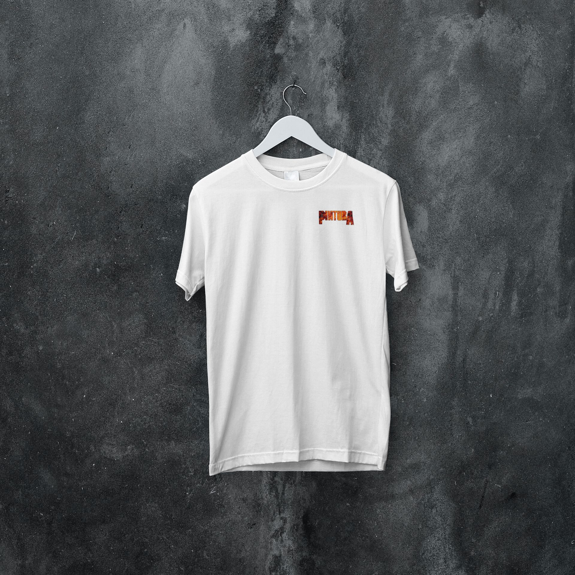 A white t-shirt is hanging on a hanger against a black wall
