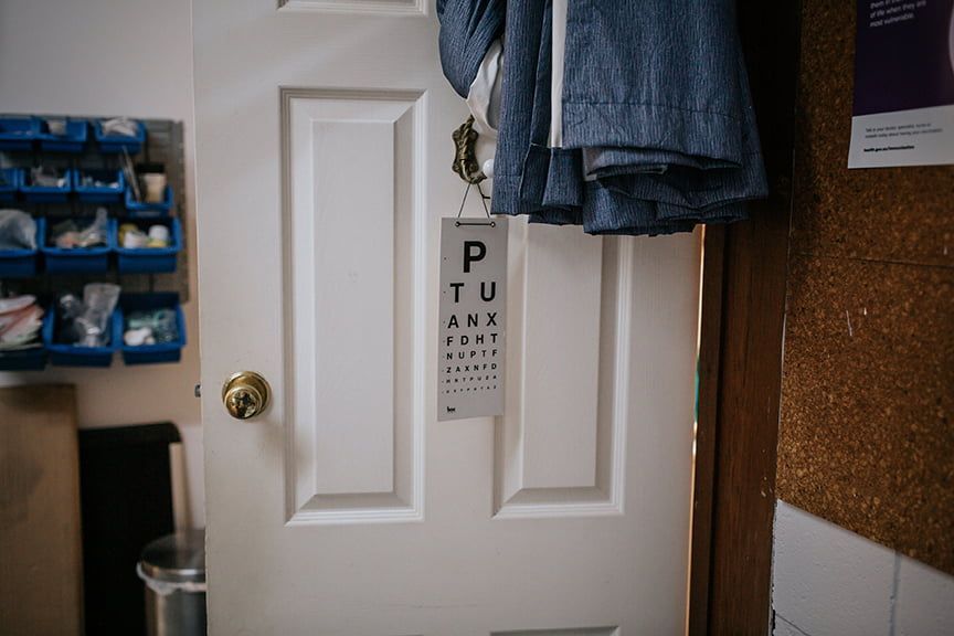 Eye Chart Hanging On A White Door — Rural Medical Clinic In Manilla, NSW