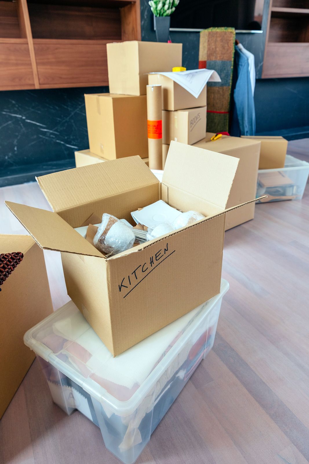Cardboard boxes and craft supplies arranged on a table in a home workspace