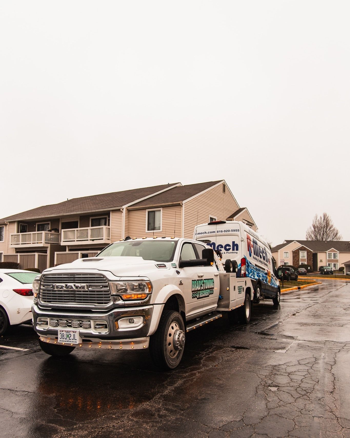 A white truck is parked on the side of the road in front of a building.