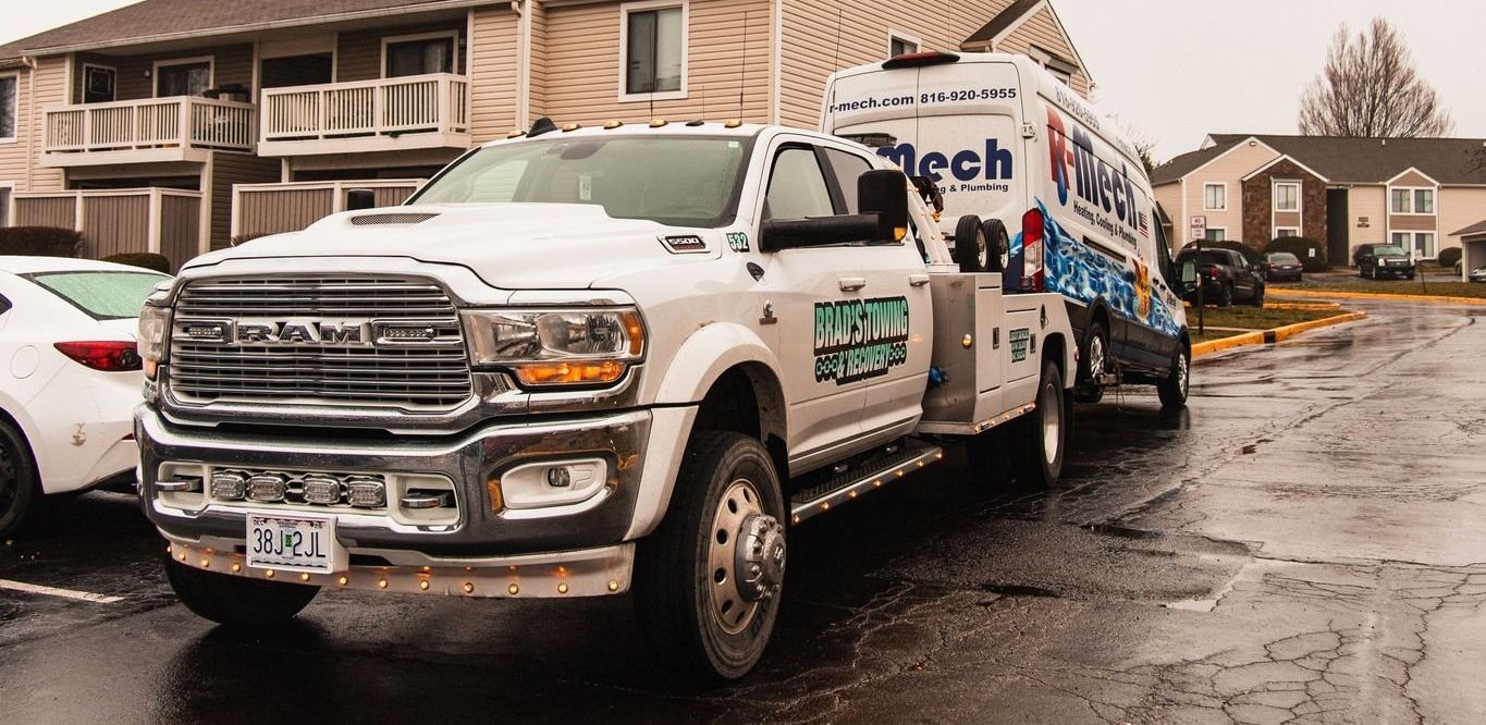 A white truck is parked on the side of the road in front of a building.