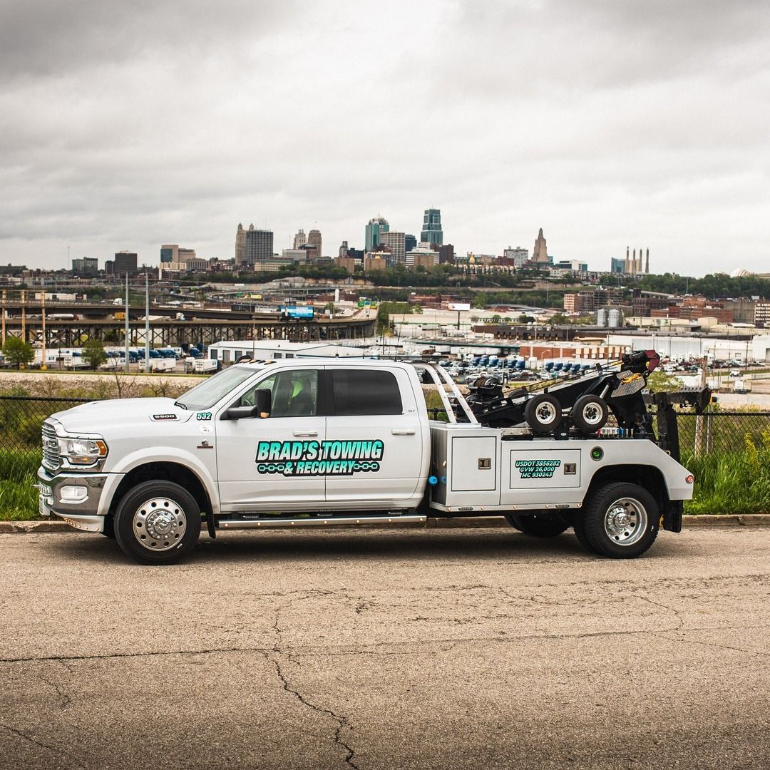 A white tow truck is parked on the side of the road.