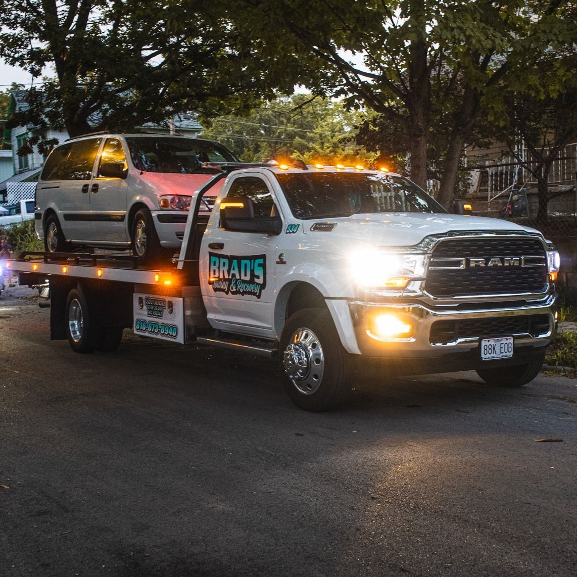 A tow truck is towing a car on a flatbed trailer.