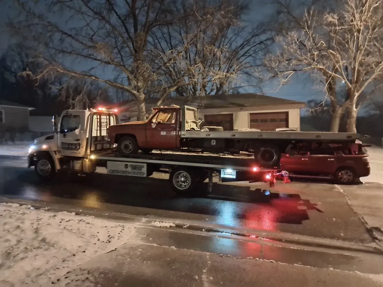 Flatbed tow truck providing urgent light duty auto towing for an SUV near the T-Mobile Center in Downtown Kansas City.