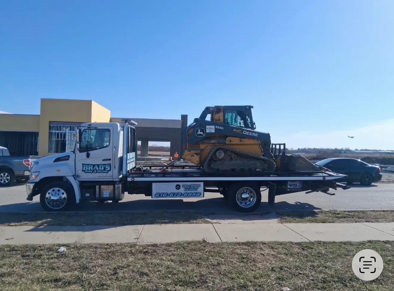 Wrecker/tow truck towing heavy machinery near Claycomo, MO