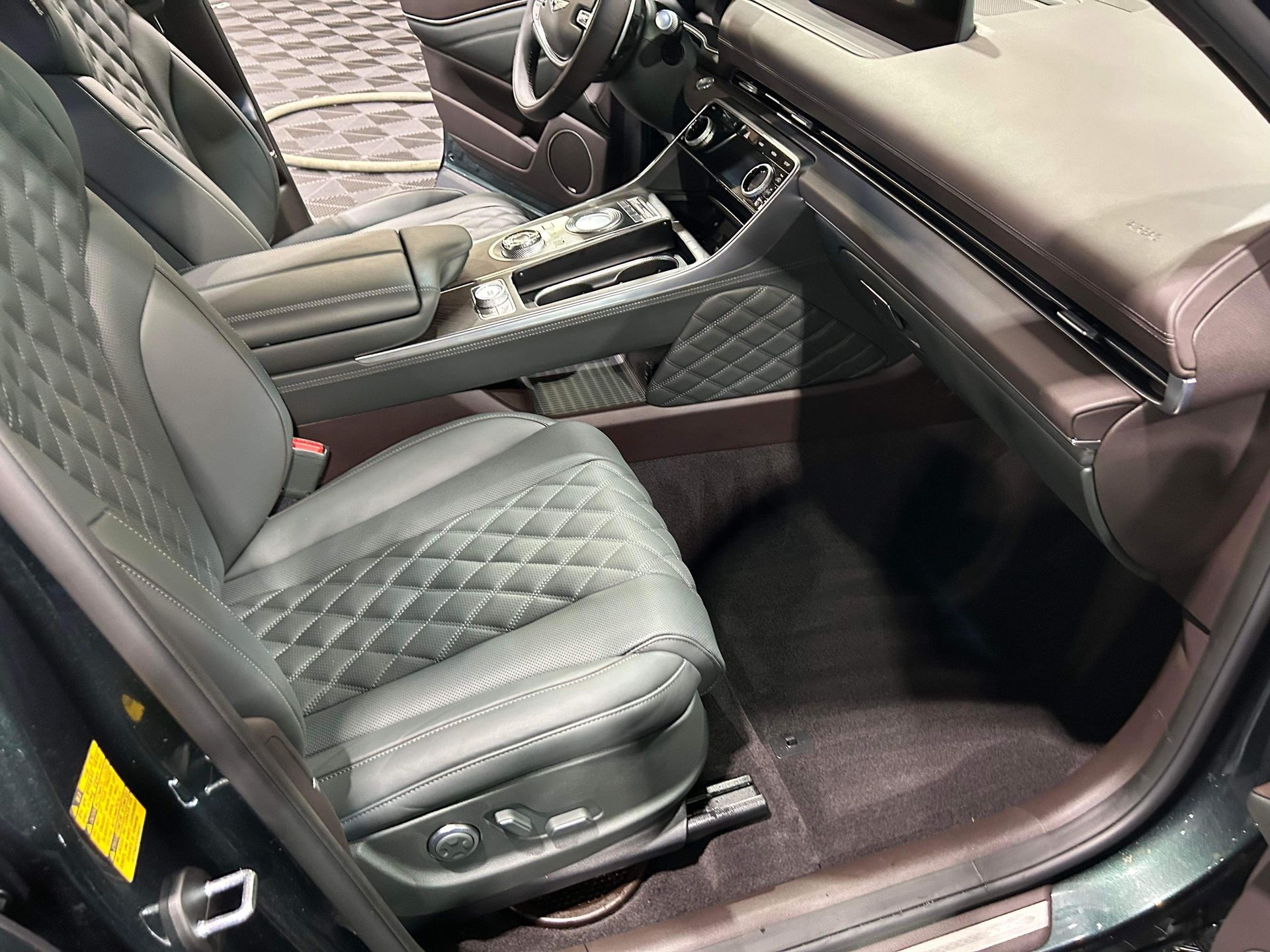 Luxury car interior with black diamond-stitched leather seats and glossy wood trim