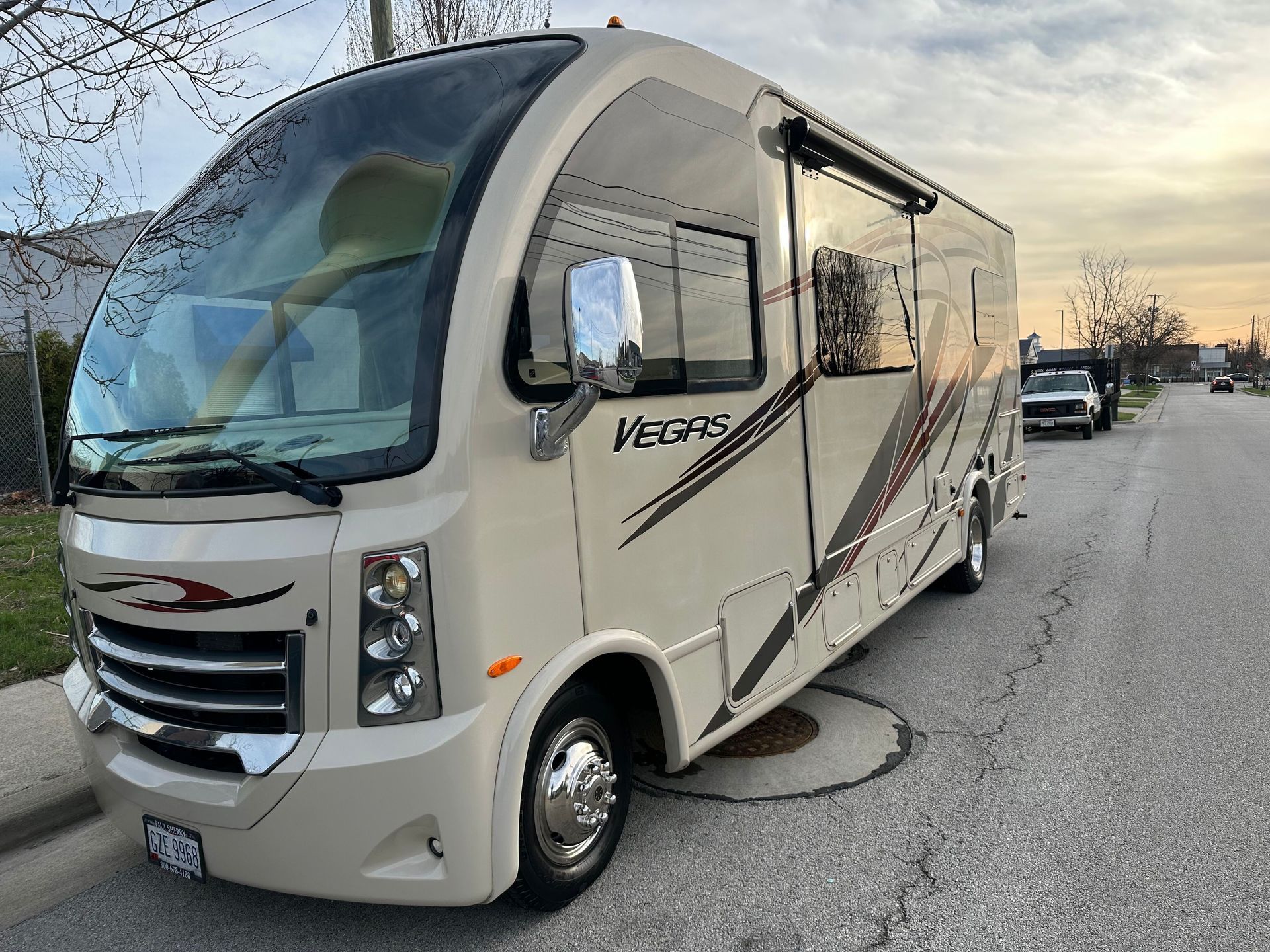 White RV motorhome parked on a snowy roadside under a cloudy sky