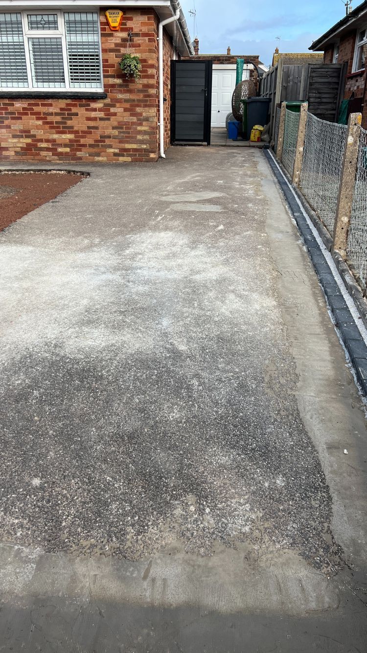 Driveway prepared for new surface with repairs done to damaged areas on the base.