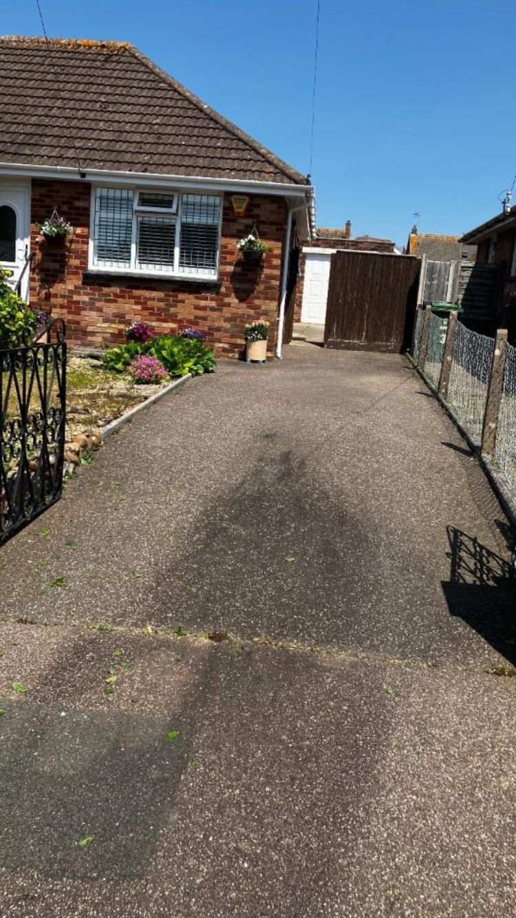 Old tarmac driveway which has faded because of the sun.