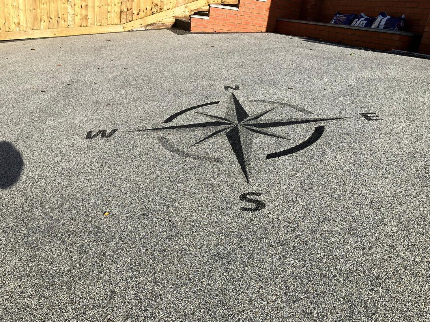 Compass shape on 2-tone grey resin driveway.