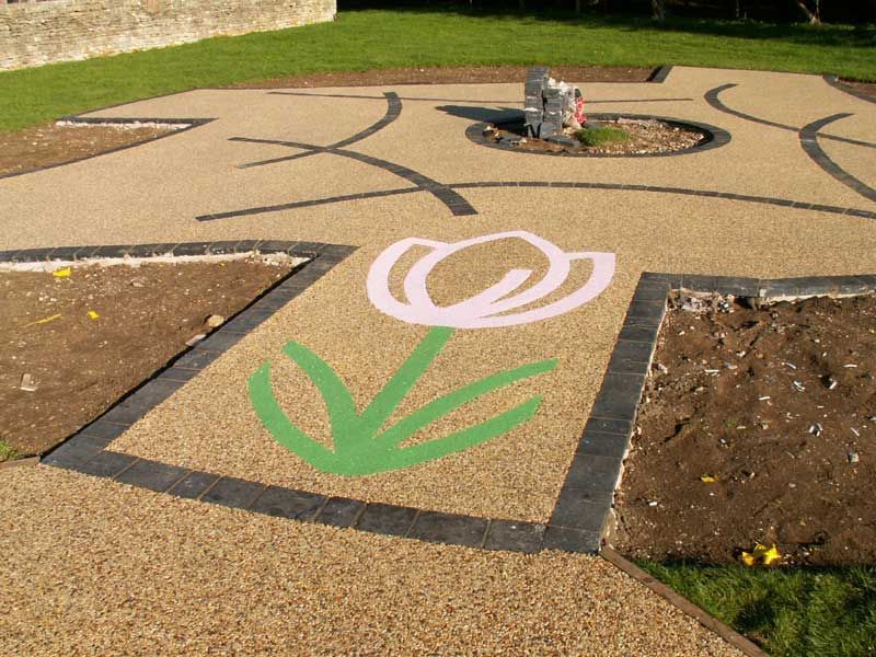 Commercial resin area with flower pattern and black block paviors.