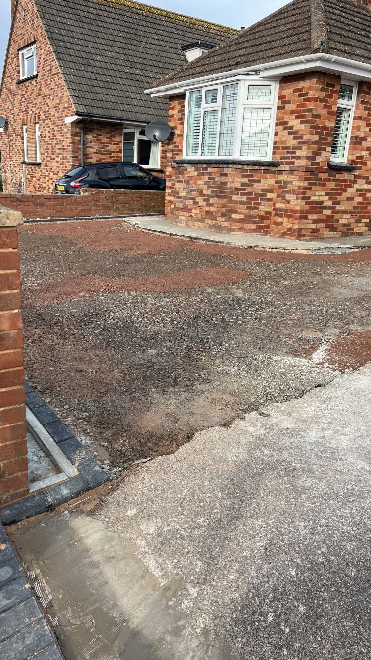 A dug up front garden which is now composed of hardcore.