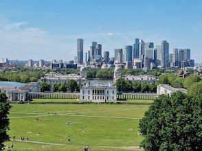An aerial view of a city skyline with a large grassy field in the foreground.