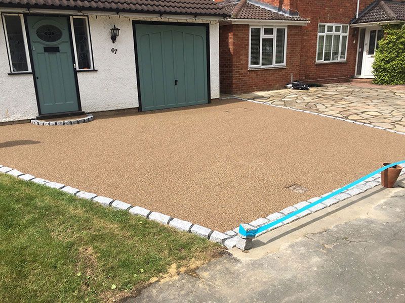 Golden resin driveway with granite sets as edges.