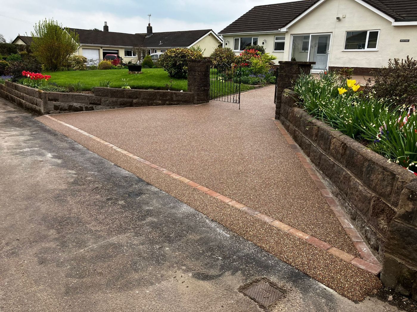 Brown colour driveway with red edging across the front.