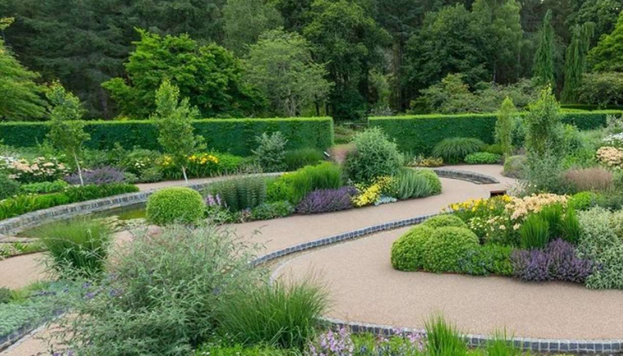 Commercial resin pathway area with driveway entrance and green plants around the pathways.