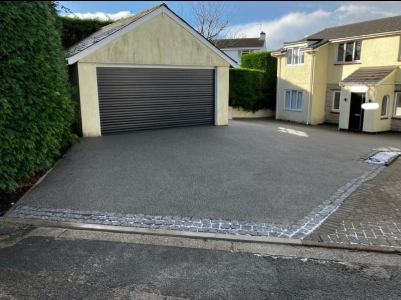 Resin driveway installation with granite set edges.