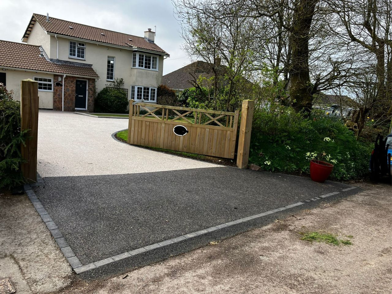 A new resin driveway in a white colour with black on the entrance.