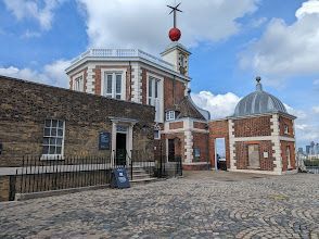 A large brick building with a red ball on top of it.