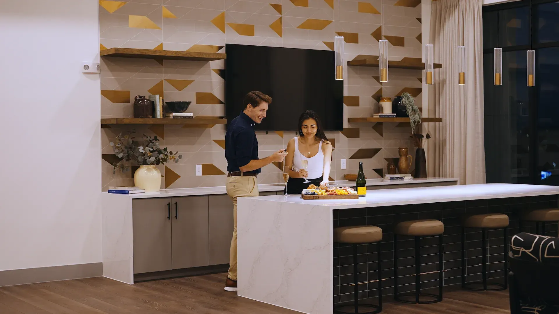 Two residents preparing food at the coworking lounge kitchen island.