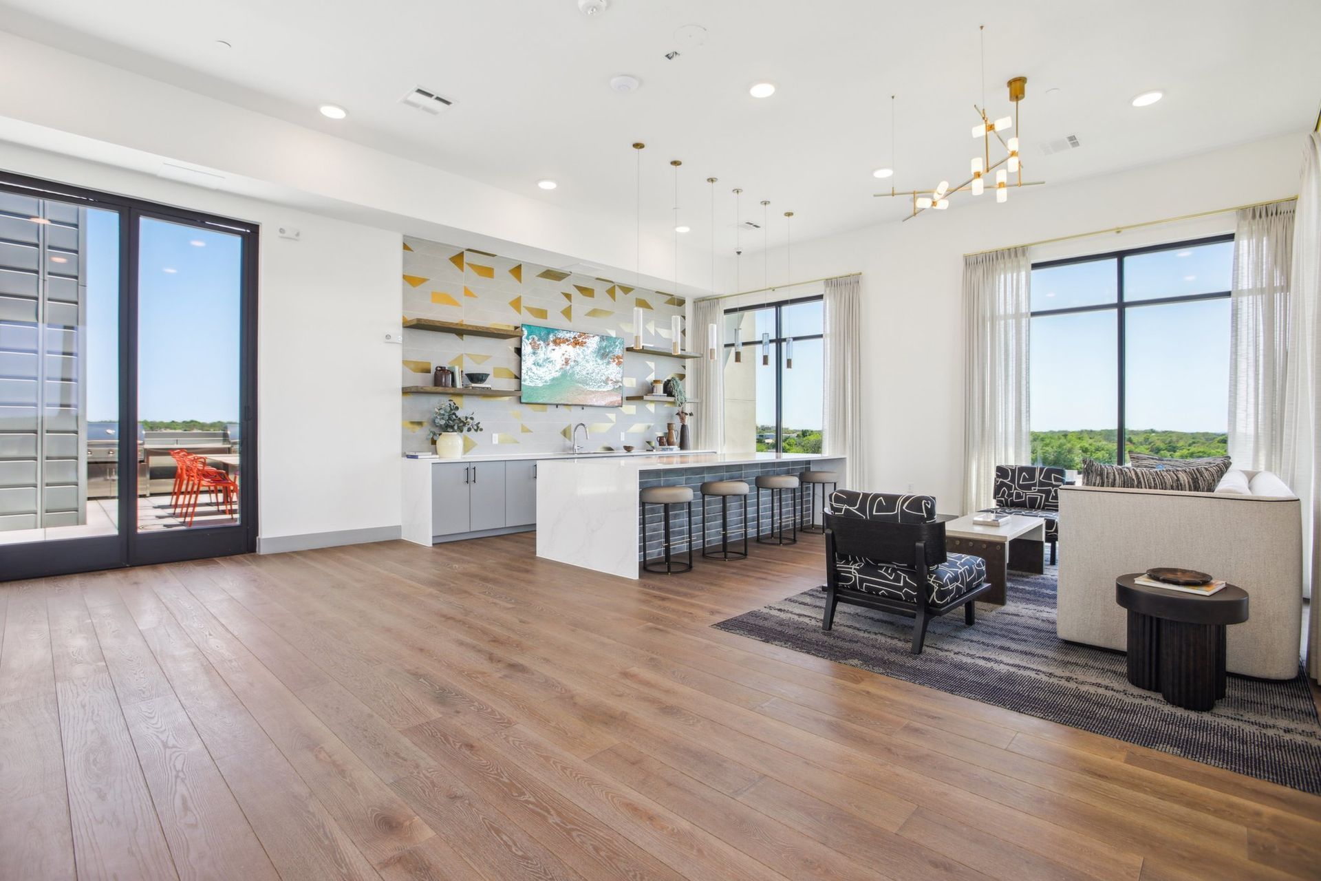 Sky lounge with island seating, a chandelier and windows on two sides.