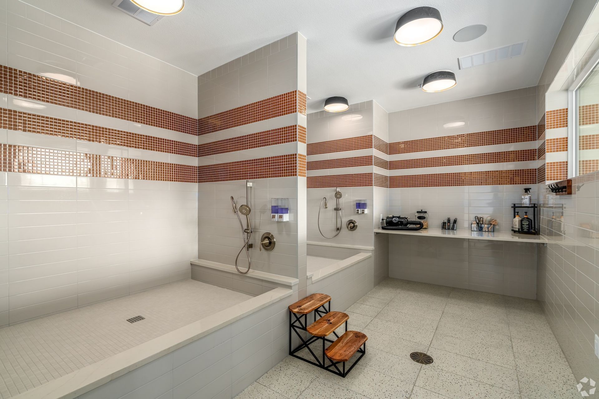 Pet spa with a tiled wash basin, pet ramp steps and grooming supplies.