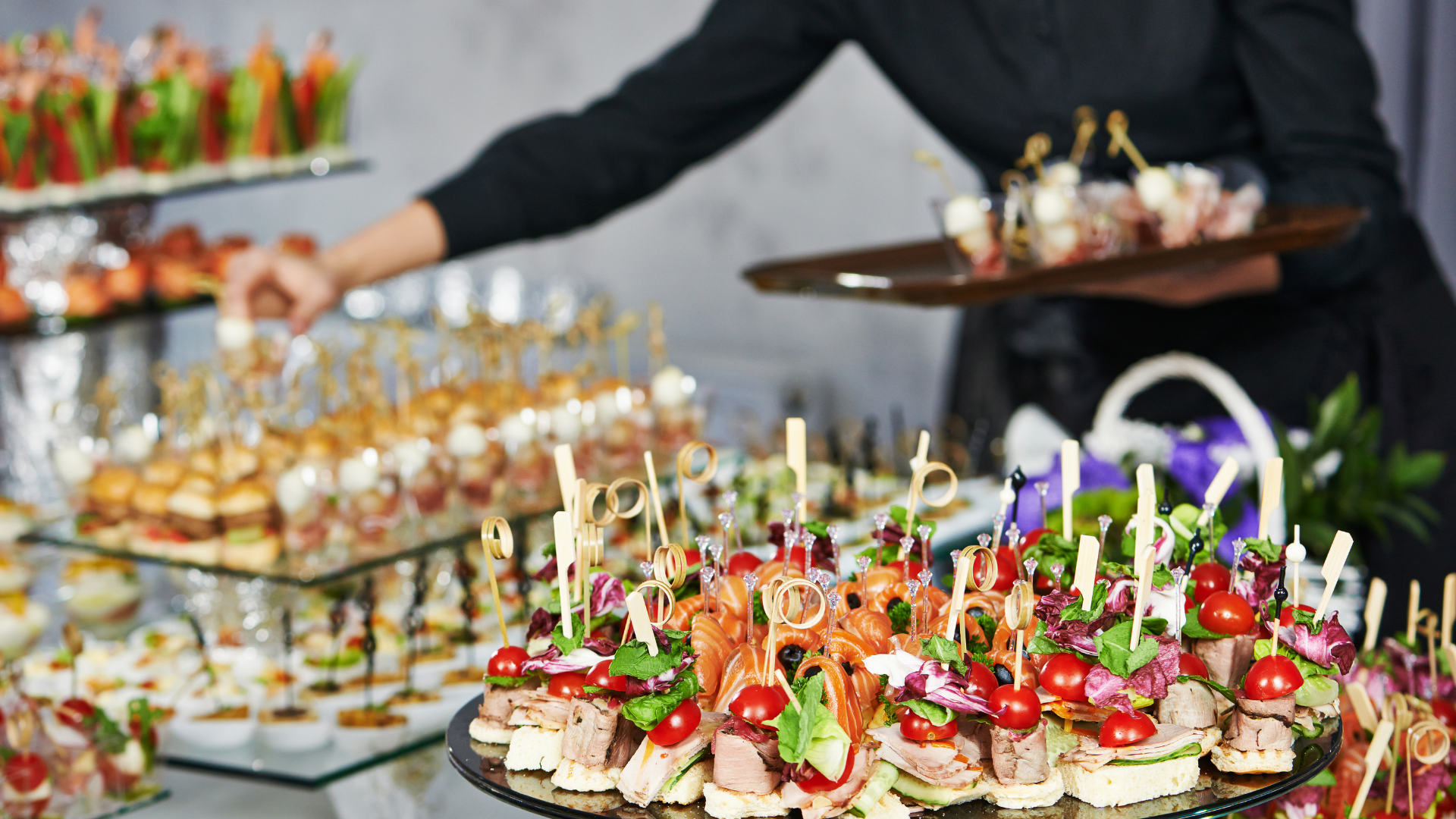 Tray of colorful bite-sized appetizers on skewers at a catered buffet table