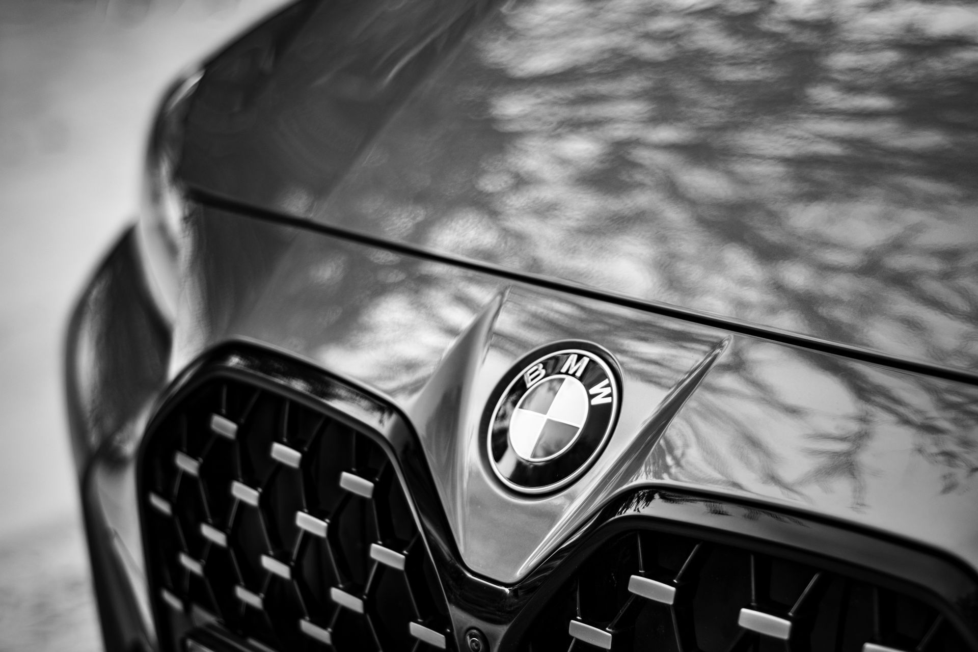 A black and white photo of a suv driving down a dirt road.