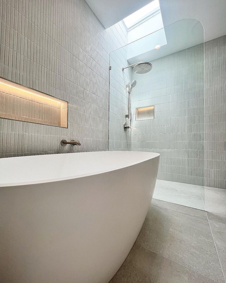 Modern bathroom with white walls, patterned floor tiles, and a wooden vanity.