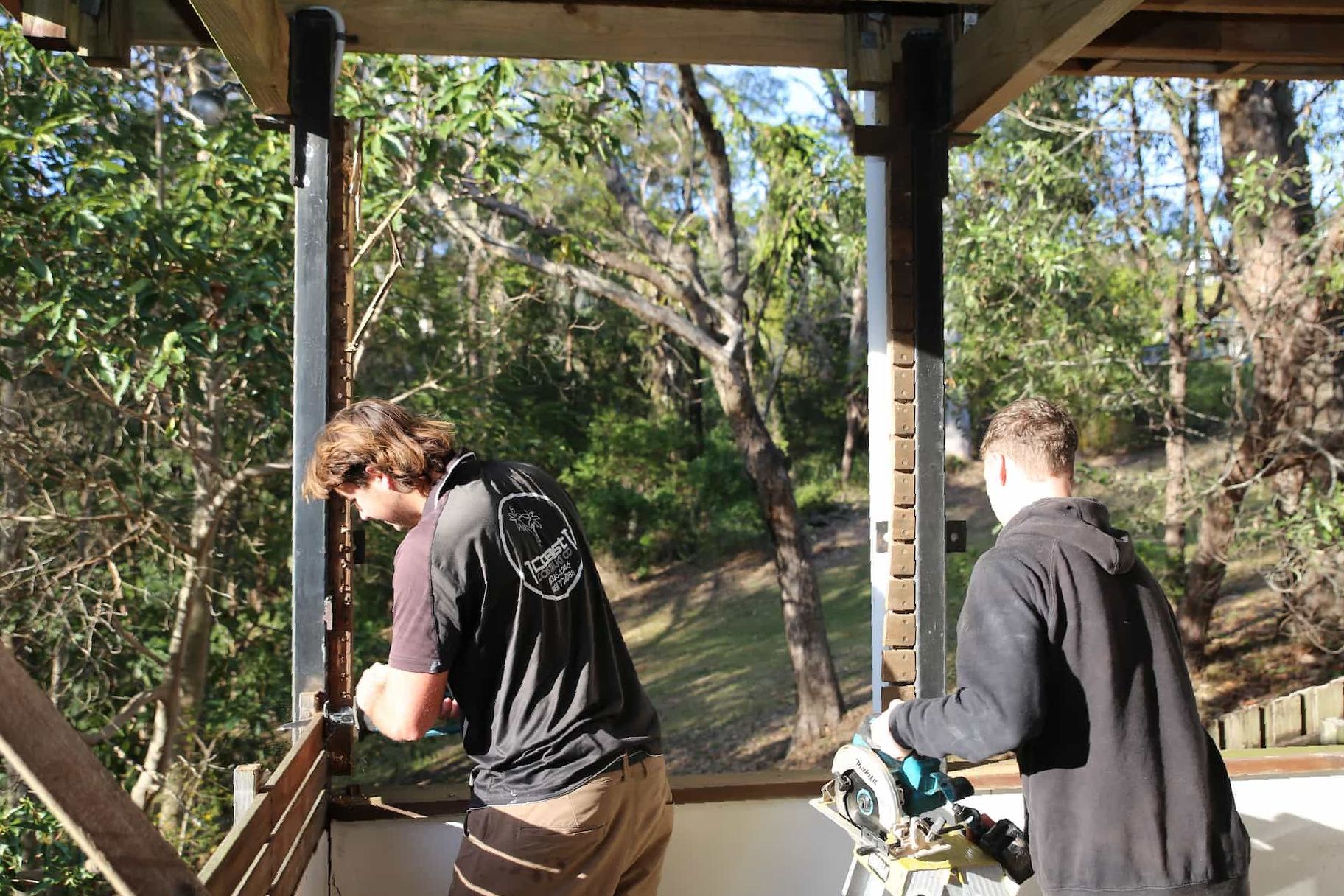 Two people extending a home using tools