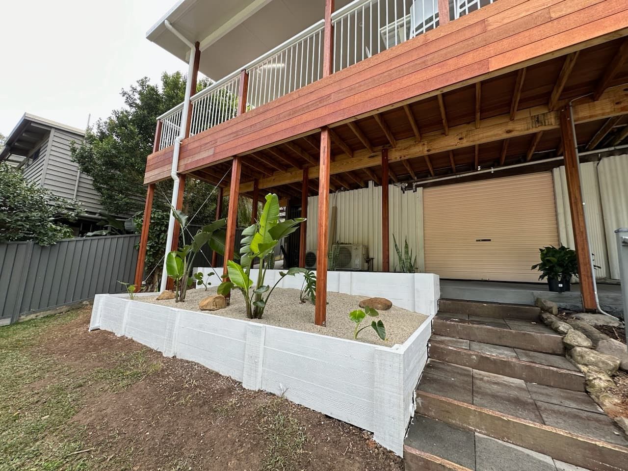 a finished house extension with a wooden deck and stairs leading up to it