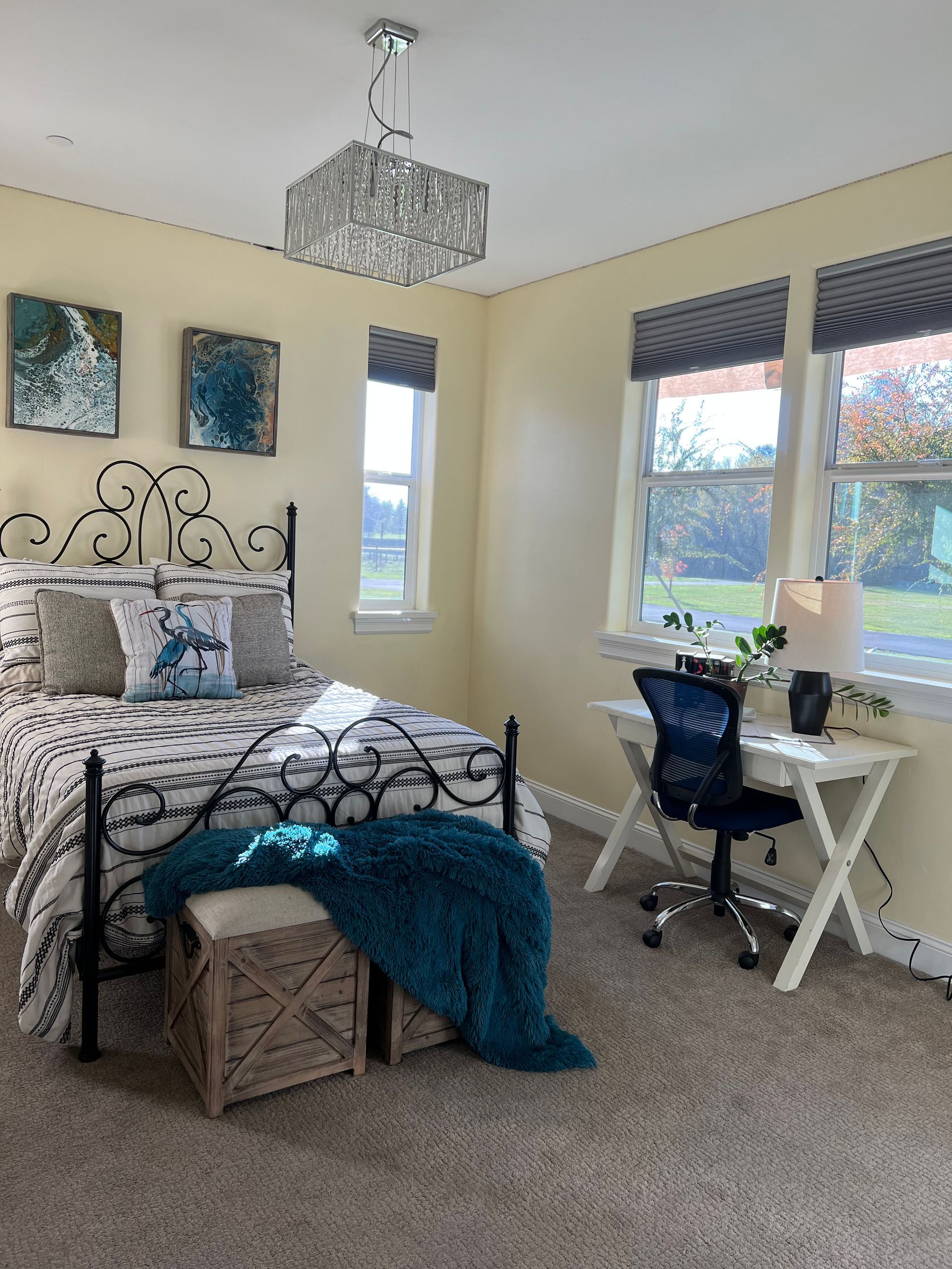 Bedroom with a bed, desk, and decorative elements in teal and cream.