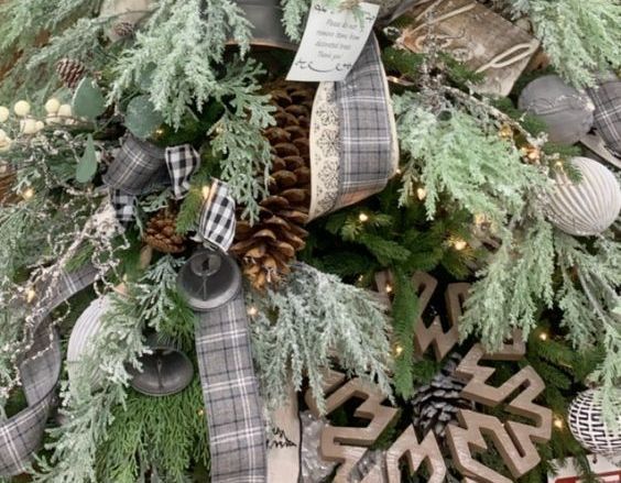 Christmas tree decorated with plaid ribbon, pinecones, and snowflake ornaments.
