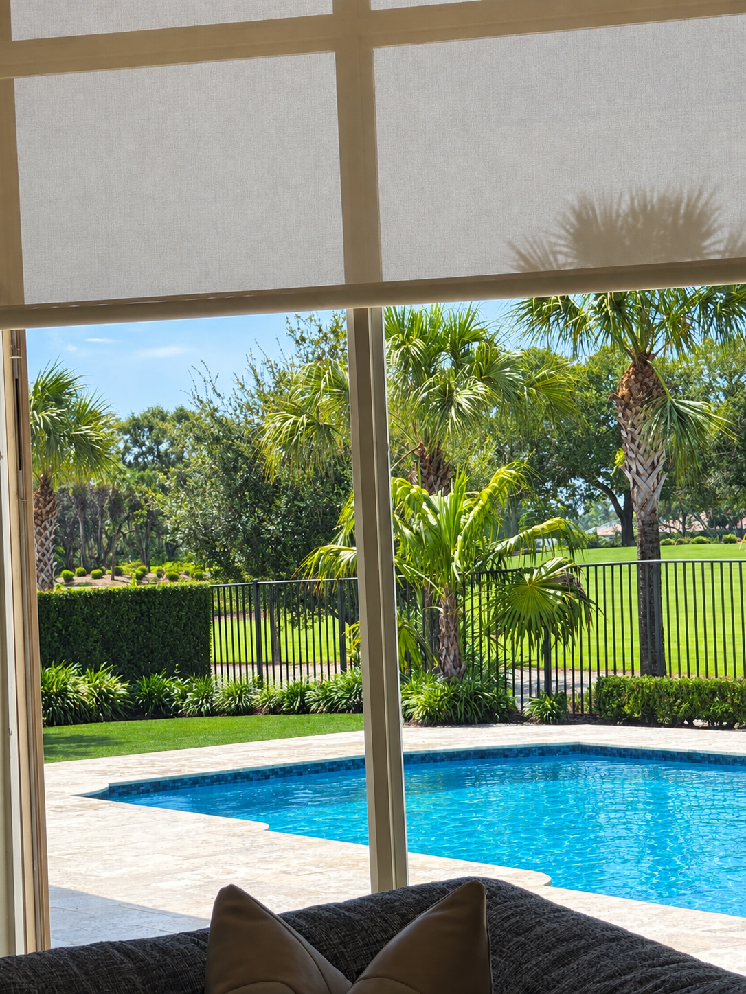 White French doors in a light-colored room open to a backyard with green lawn and trees.
