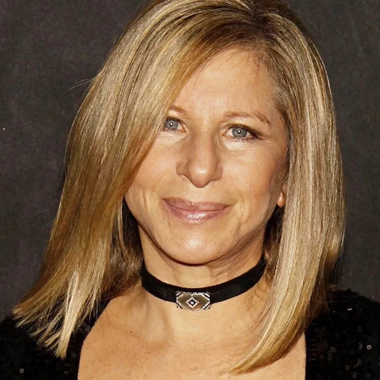 Barbra Streisand with shoulder-length blonde hair, wearing a black choker necklace, smiling against a dark background.