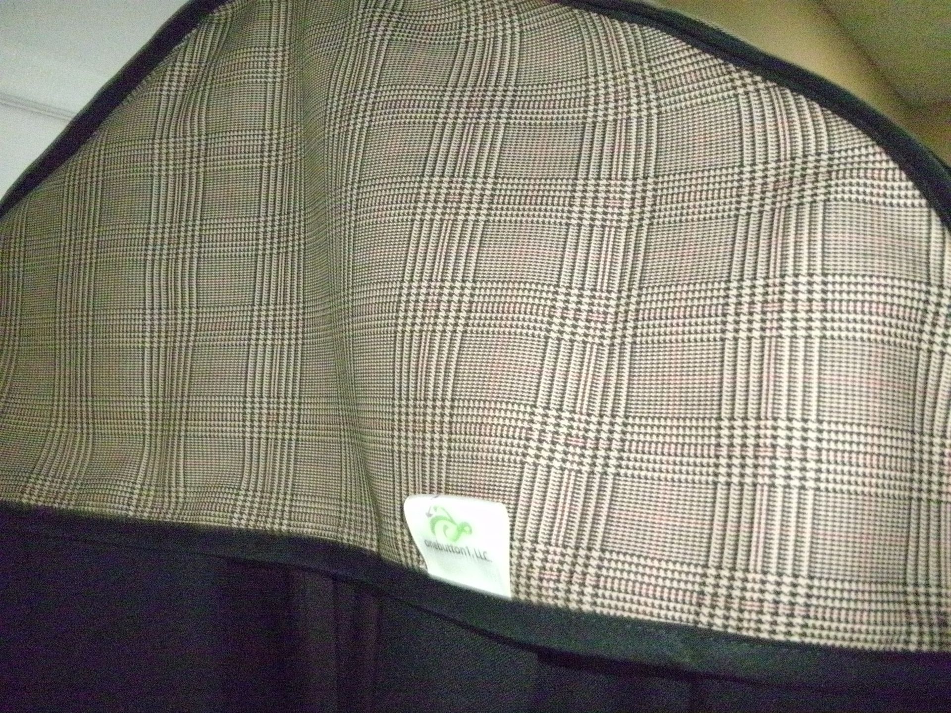 Close-up of a plaid fabric bag or case with a black bottom and small white label