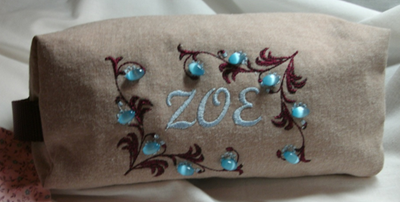 Beige embroidered pouch with blue floral accents and the number 302 stitched in the center.