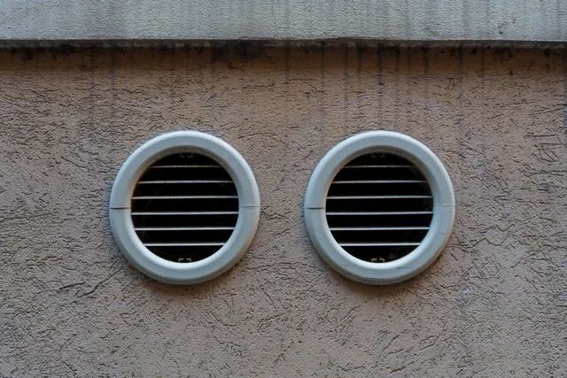 Two round vents are on the side of a building.