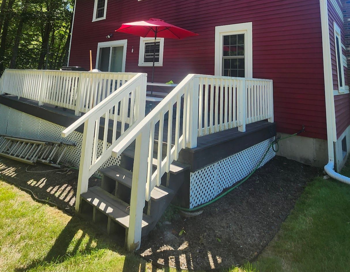 Red house exterior with a white ramp and steps leading to a porch.