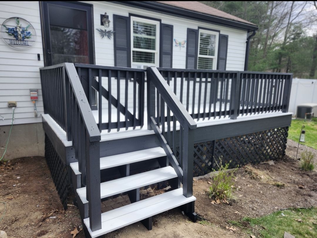 Black-and-white front porch deck with stairs and railing on a house exterior
